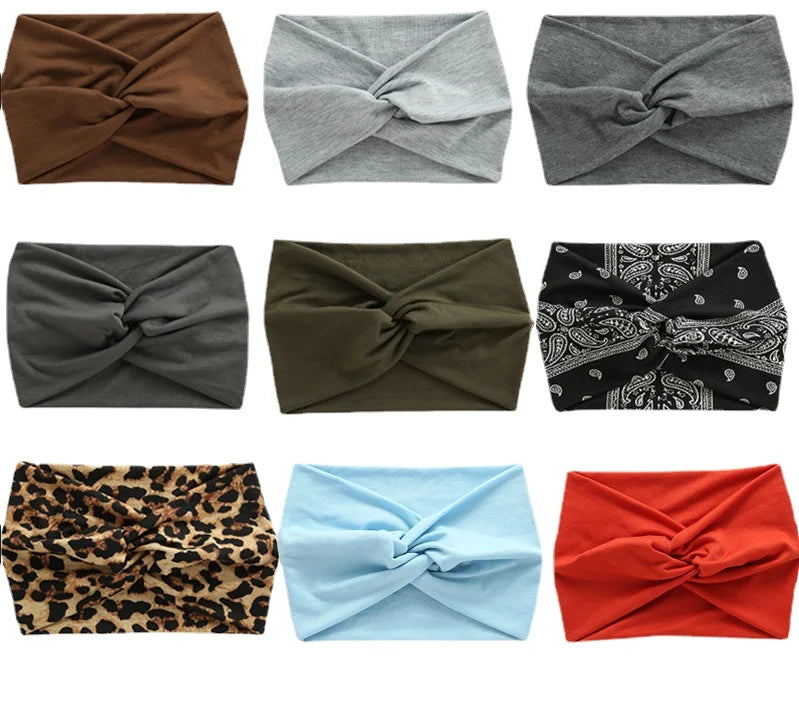 A collection of nine women's elastic sports headbands in various colors and patterns.