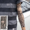 A person wearing a gray striped shirt displays an arm covered in black and gray tattoo-style sleeves.
