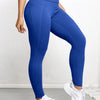 A woman wearing royal blue high-waisted sports leggings and white sneakers.