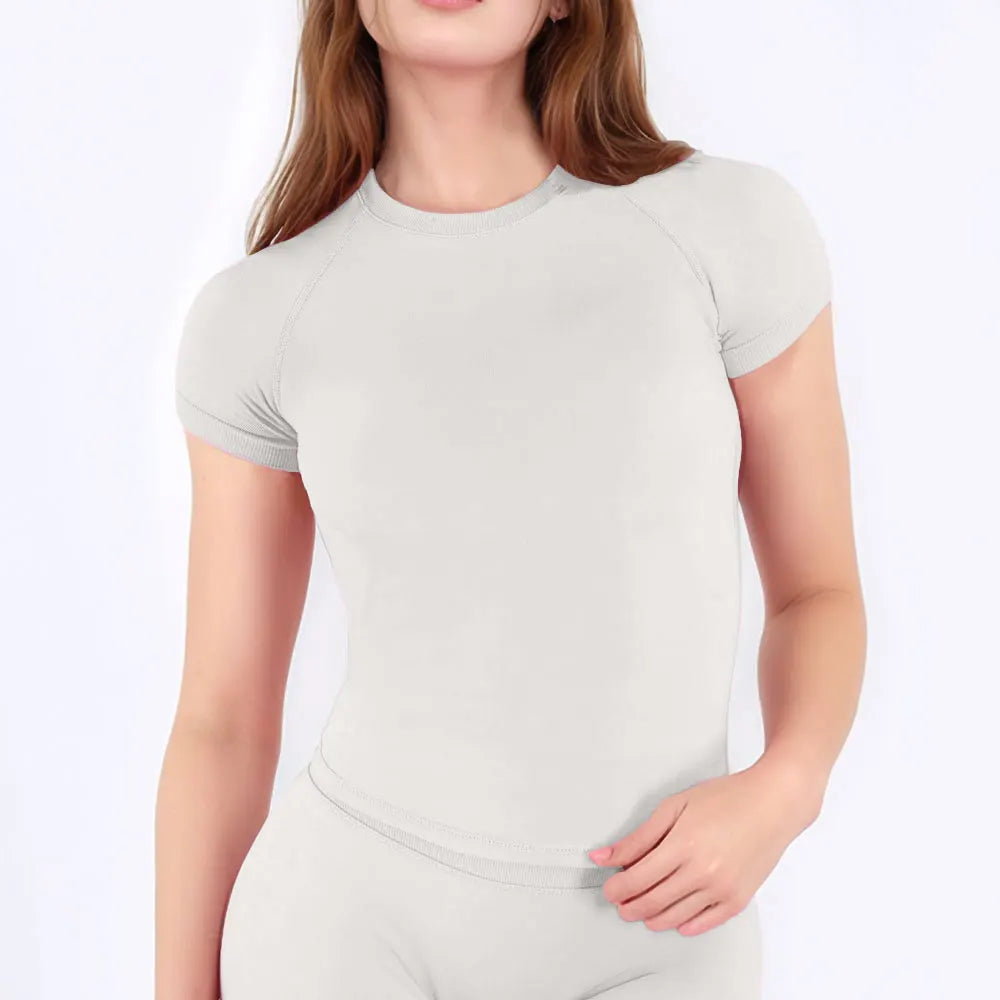 A woman wearing a light gray performance fitness short sleeve top.
