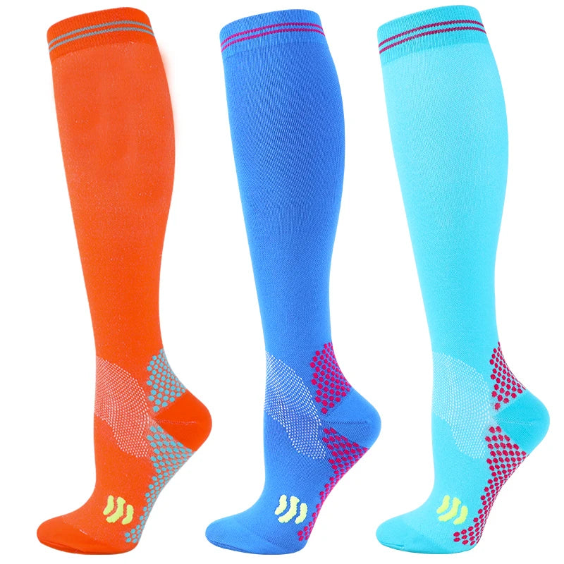 Three pairs of medical grade compression socks in orange, blue, and cyan.