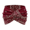 A deep maroon fabric headband featuring paisley embroidery and a twisted design.