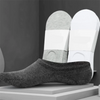 A pair of gray invisible silicone no-show boat socks displayed next to white insoles.
