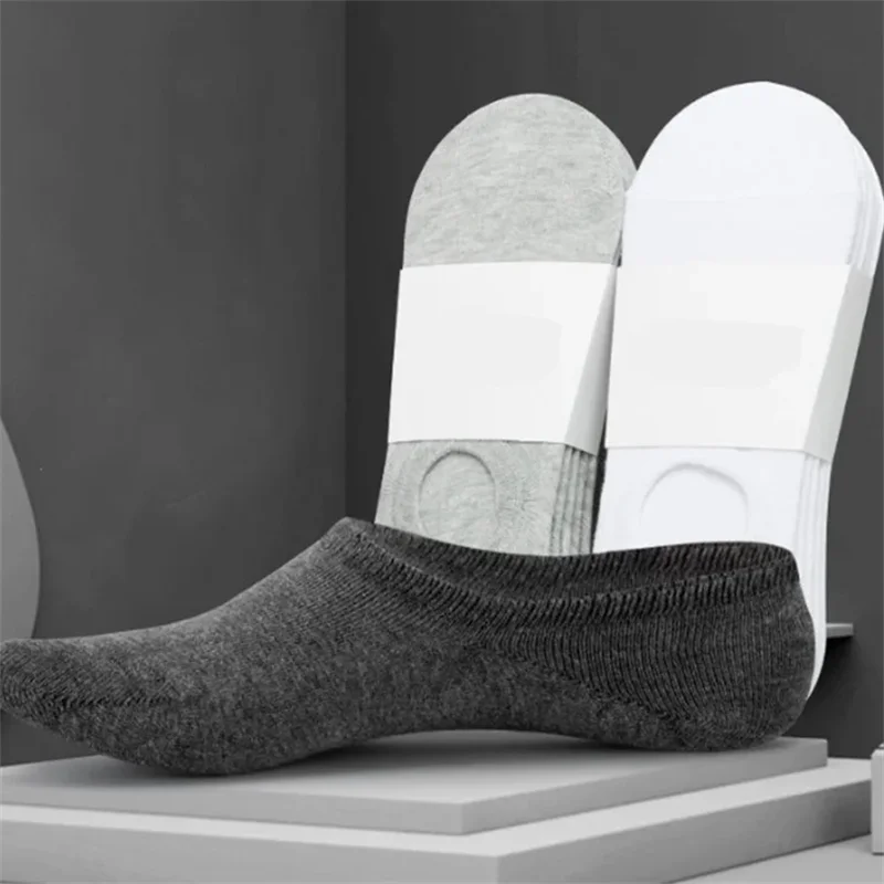 A pair of gray boat socks with white accents displayed next to a dark gray sock.