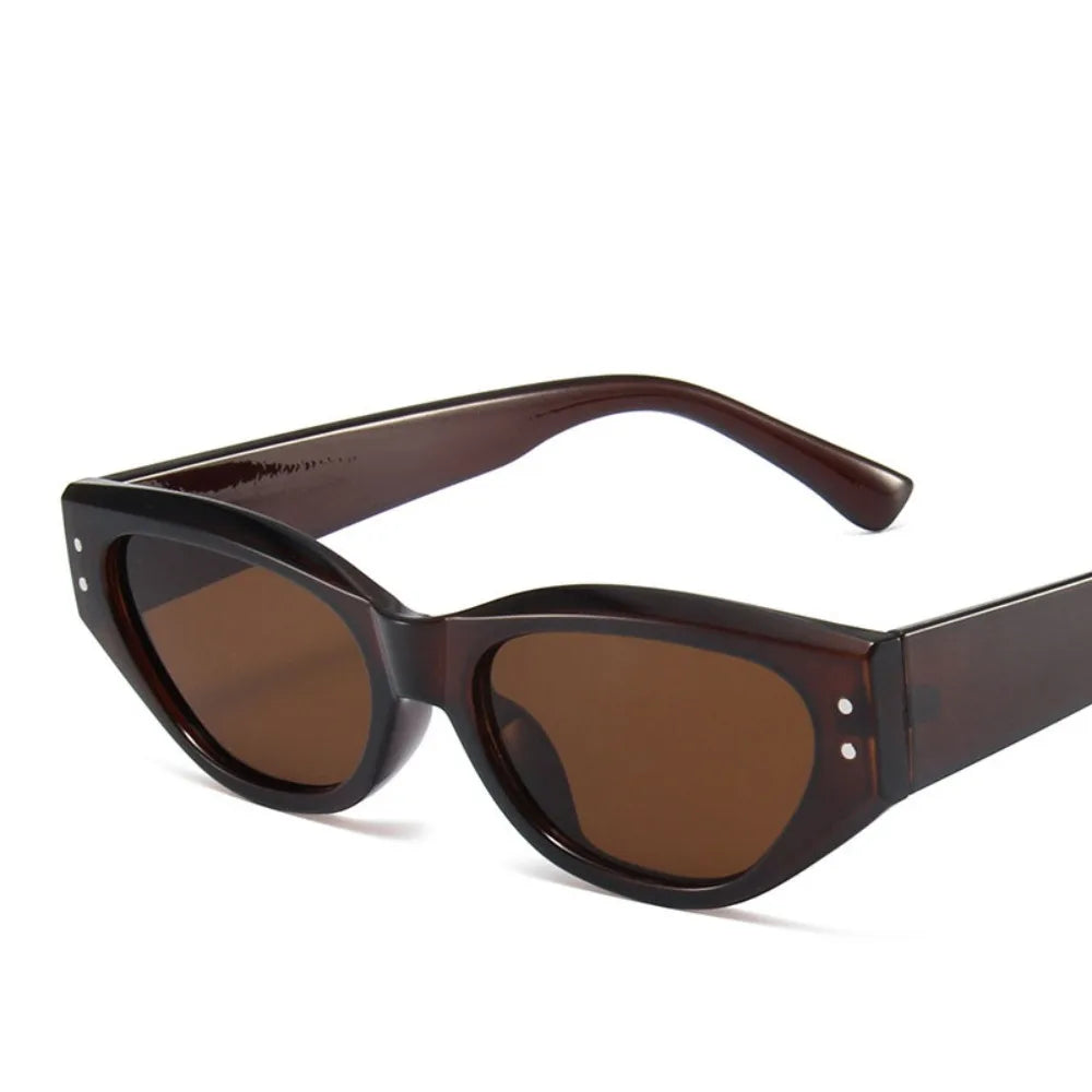 Brown tinted sunglasses with a cat eye shape and small rhinestone details