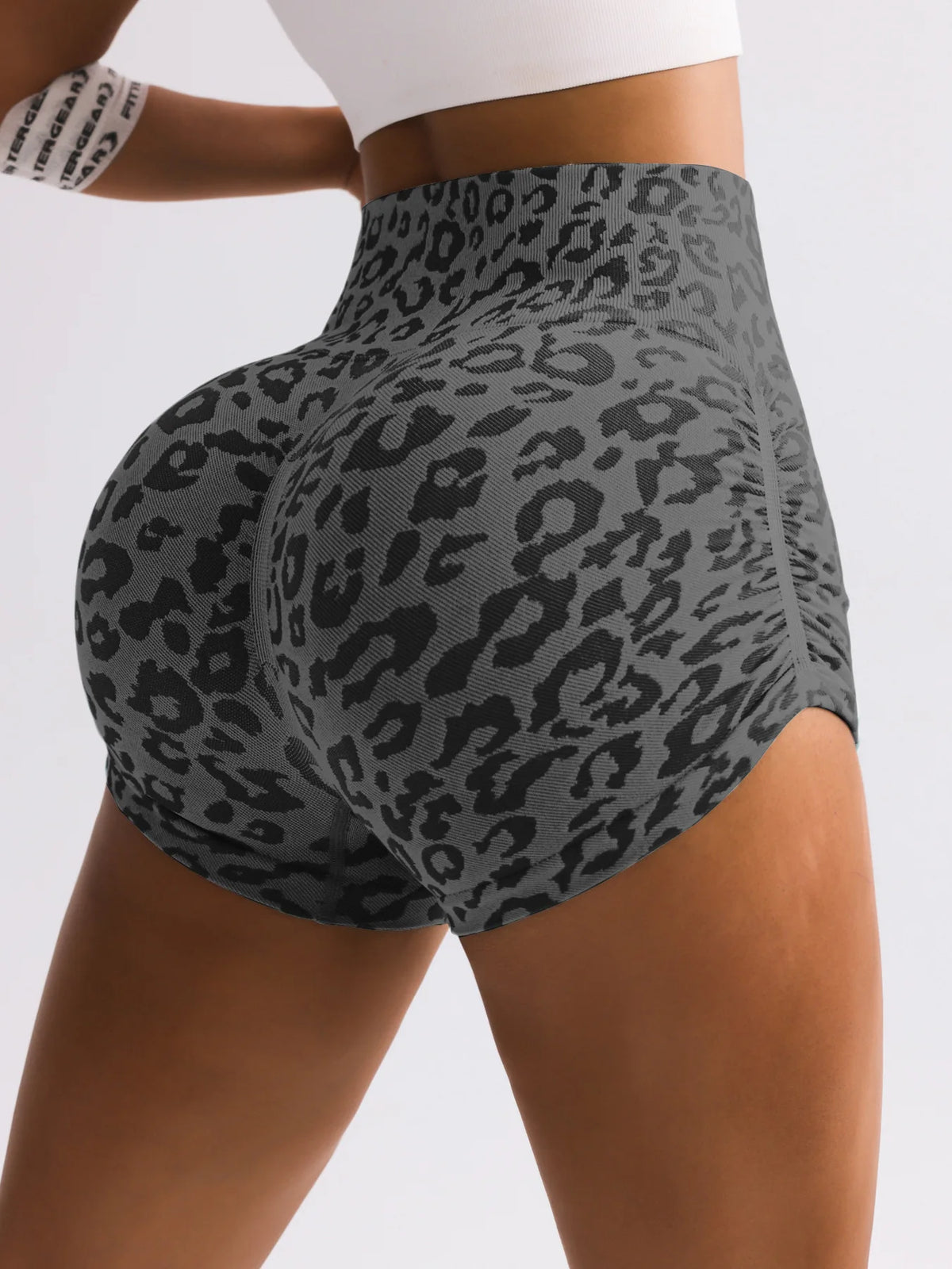 A woman is wearing leopard print high-waist seamless shorts.