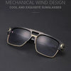 A pair of black and gold framed sunglasses with a square lens resting on a dark surface.
