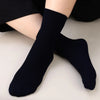 A pair of navy blue bamboo fibre anti-odor socks worn on a person's foot.