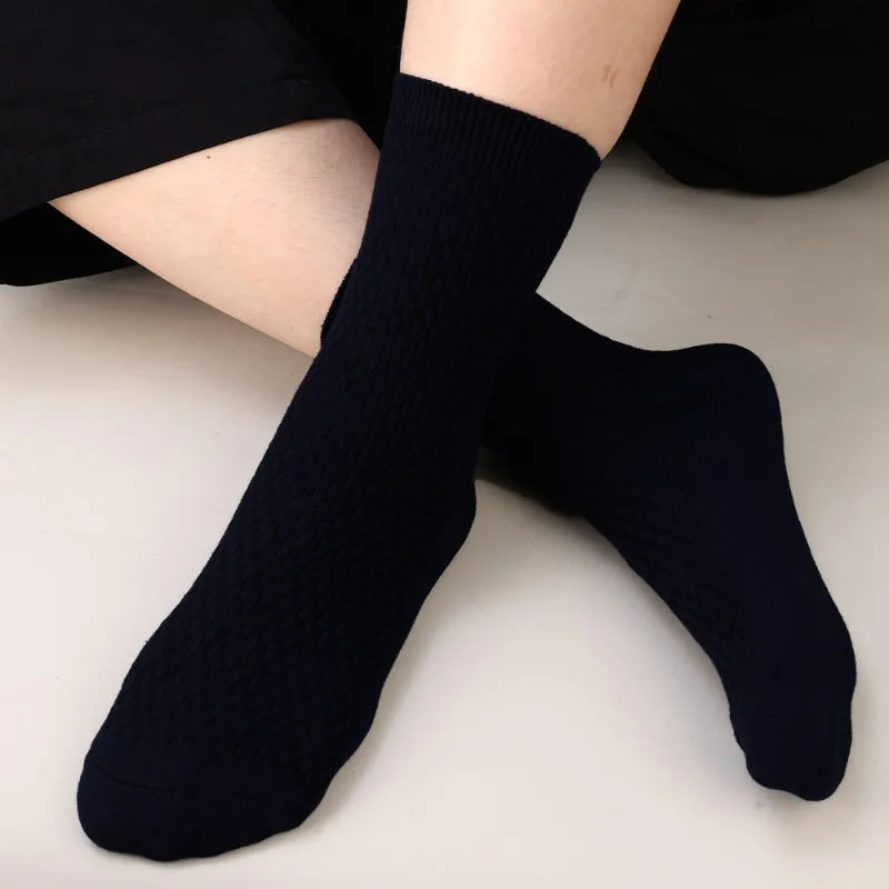 A pair of navy blue bamboo fibre anti-odor socks worn on a person's foot.