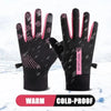 A pair of black thermal cycling and running gloves with pink accents shown against a snowy background.