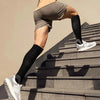 A person wearing compression socks is shown climbing outdoor stairs.