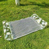 Clear mesh inflatable pool float hammock decorated with white daisy patterns on a green lawn.