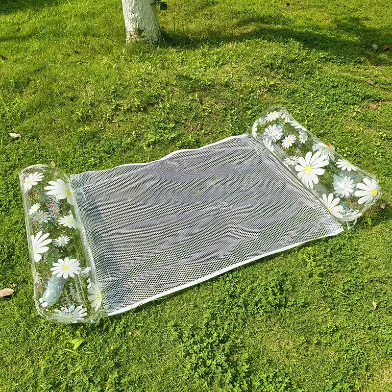 Clear mesh inflatable pool float hammock decorated with white daisy patterns on a green lawn.