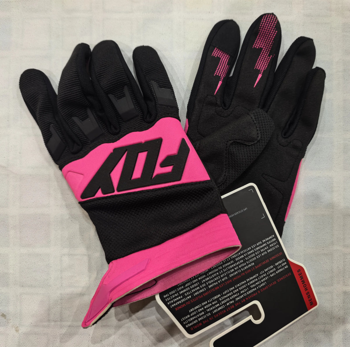 A pair of black and pink durable motorcycle off-road riding gloves are displayed on a light background.