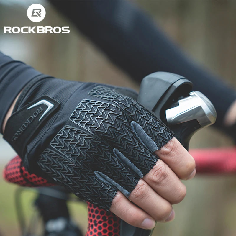 Close-up of black cycling gloves with a textured pattern being held by a hand, used for MTB riding.
