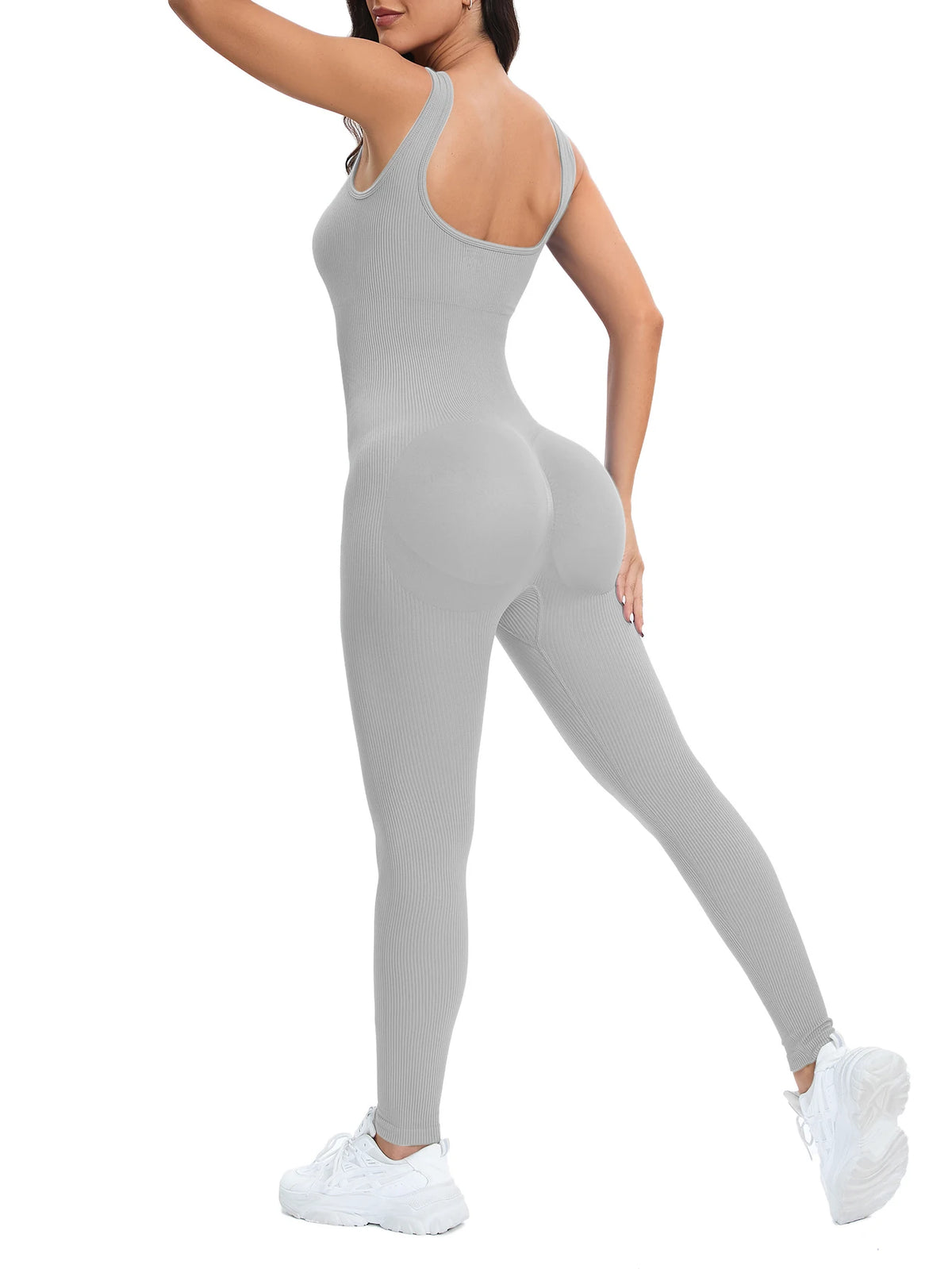 A model wearing a gray ribbed nylon bodycon jumpsuit with a high neck and long sleeves.
