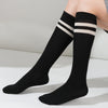 Black and white striped cotton knee high socks worn on a leg.