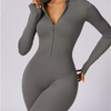 Model trägt einen eng anliegenden, langärmeligen, grauen Half-Zip-Yoga-Overall.