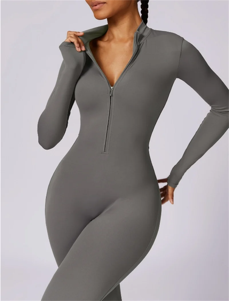 Model trägt einen eng anliegenden, langärmeligen, grauen Half-Zip-Yoga-Overall.