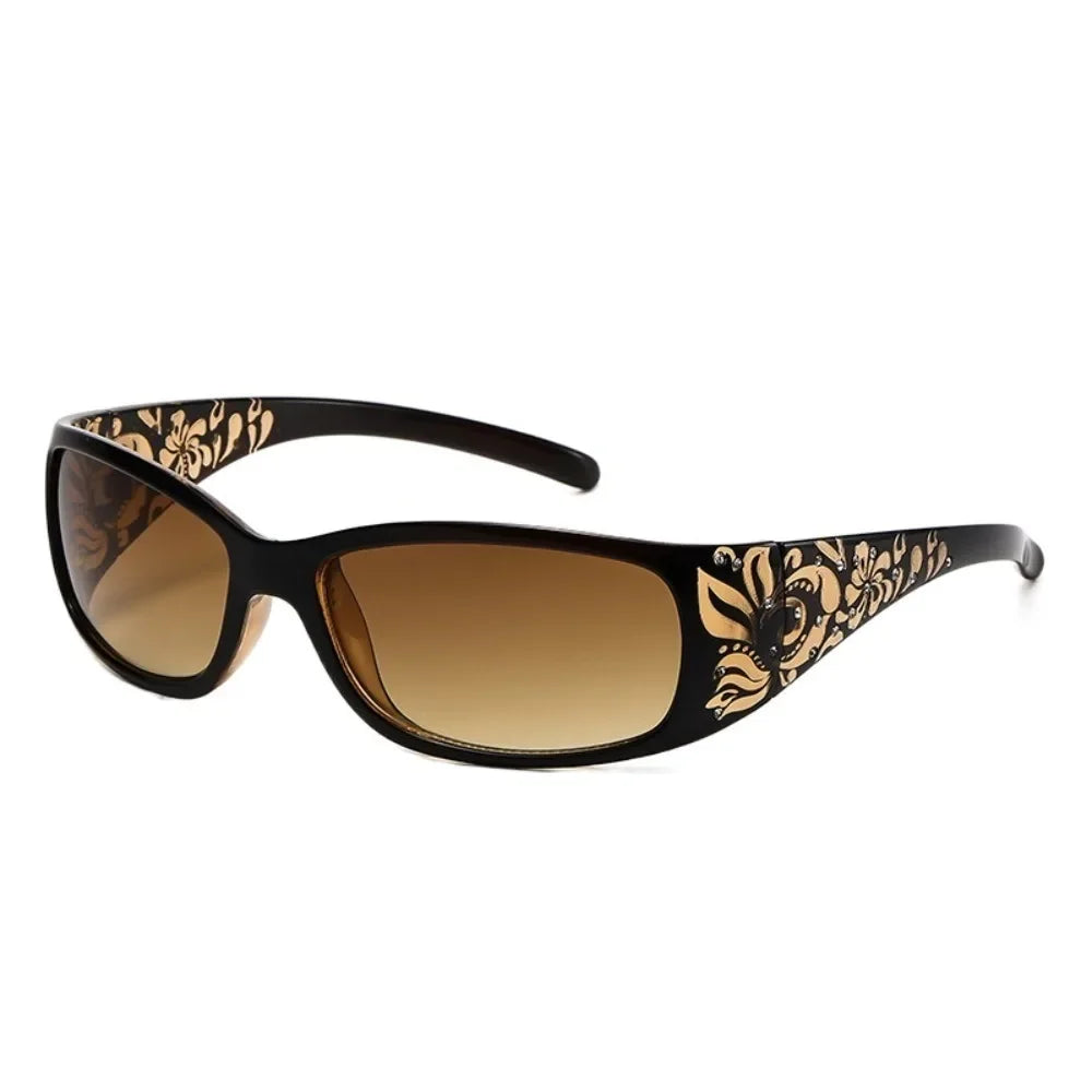 A pair of black sunglasses with gold floral detailing and a cat-eye shape.
