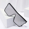 A pair of black-framed retro square sunglasses resting on a white block.