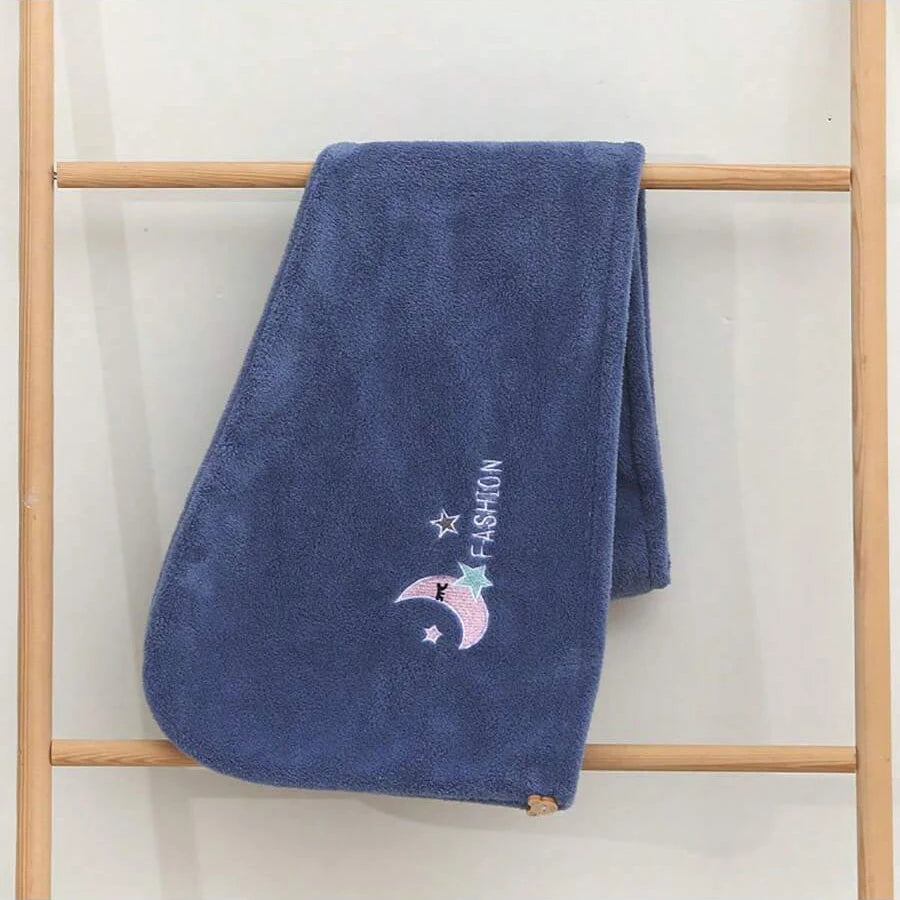 Dunkelblaue Samt-Haartrockenhaube mit Halbmond- und Sternstickerei, an einem Holzständer hängend.