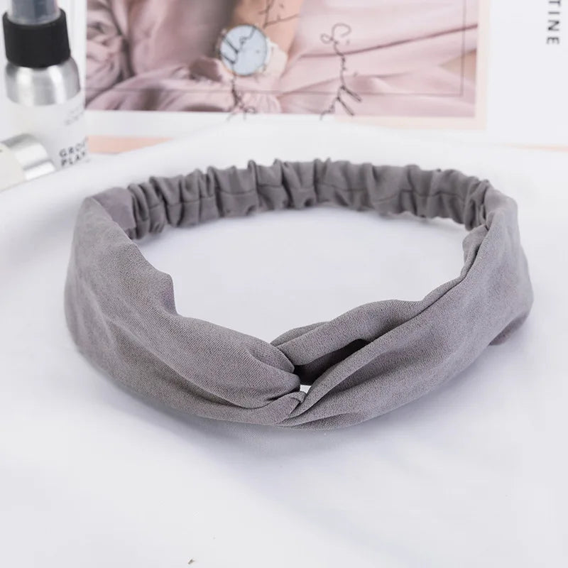 A gray bohemian chiffon headband is shown lying flat on a white surface.