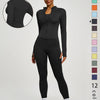 Eine Frau modelliert ein schwarzes zwei-teiliges Yoga-Set mit langärmeligem Oberteil und Leggings.