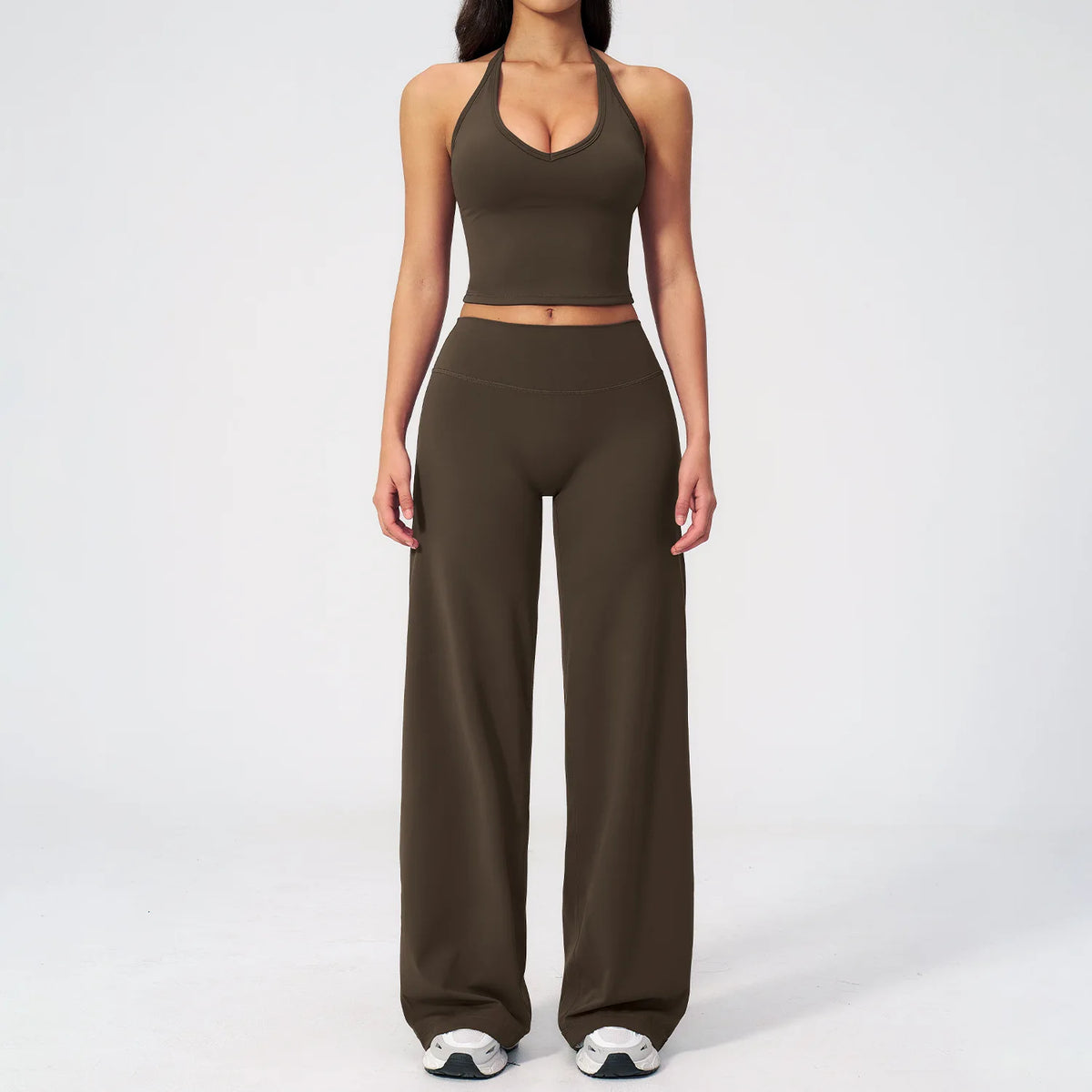 A woman wearing a dark olive green women's premium fitness tracksuit top and matching pants.