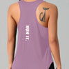 A woman wearing a purple running vest with a cat tattoo design on the shoulder.