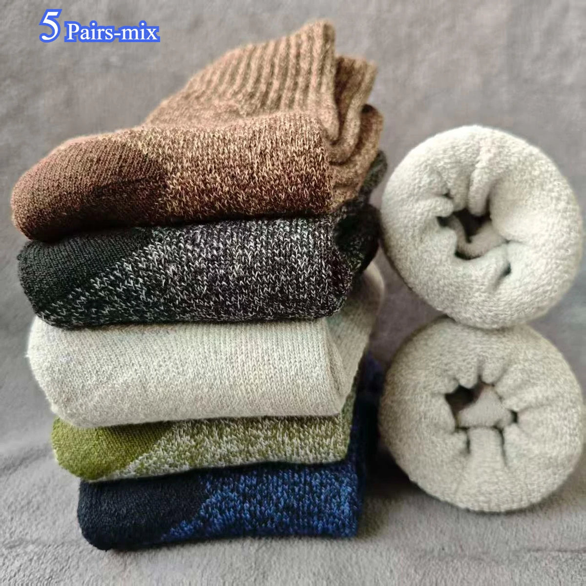 A stack of five pairs of brown, black, gray, and olive merino wool hiking socks