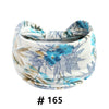 Bandeau en tissu blanc à imprimé floral bleu et feuilles, roulé pour le yoga ou l'exercice.