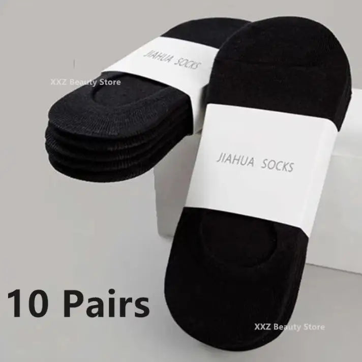 Ten pairs of black boat socks with white labels displayed on a white surface.