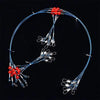 A multi-piece saltwater fishing tackle rig with red beads and wire lines is shown against a black background.