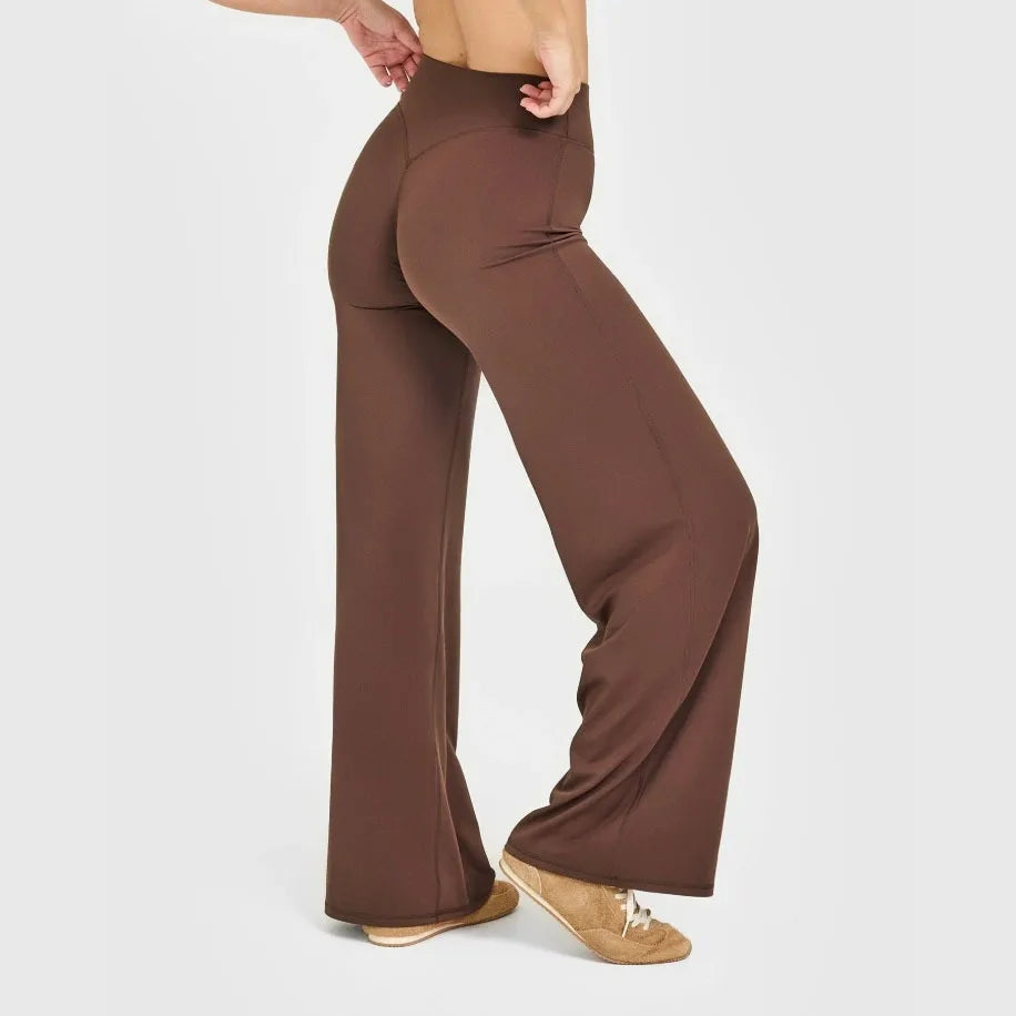 A model wearing brown high-waist yoga pants and tan shoes.