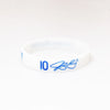 A white silicone wristband with the number 10 and a blue signature on the front.