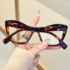 A hand holds a pair of vintage color block blue light blocking eyewear with dark brown and amber lenses.