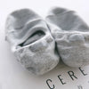 Pair of gray men's invisible silicone no-show socks lying on a white surface.
