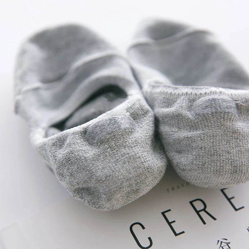 Pair of gray men's invisible silicone no-show socks lying on a white surface.