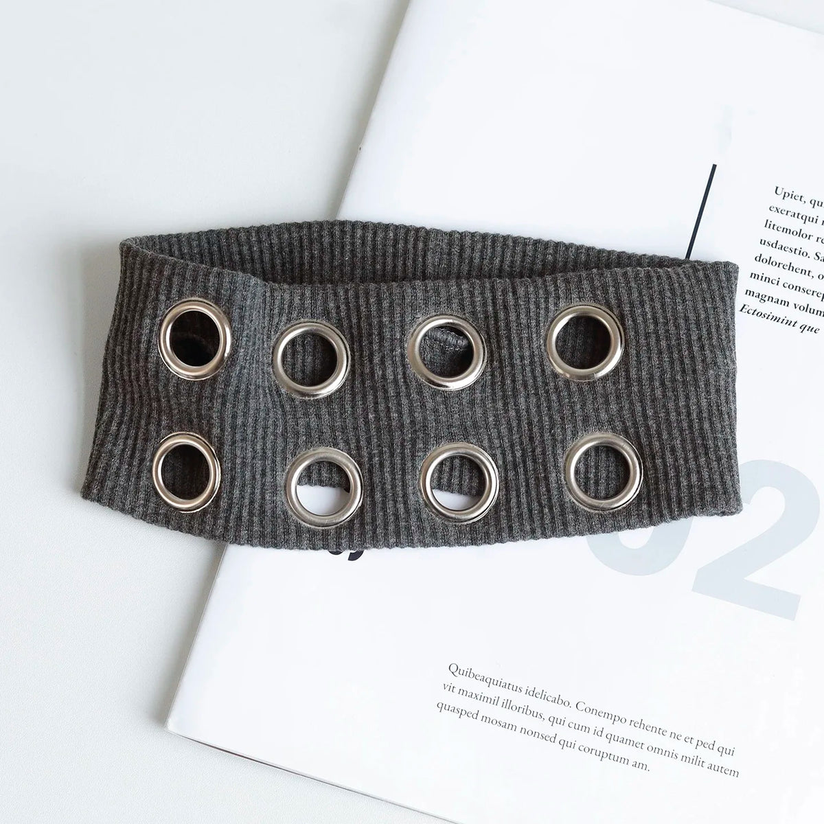 Bandeau à œillet grunge punk gris foncé sur fond blanc.