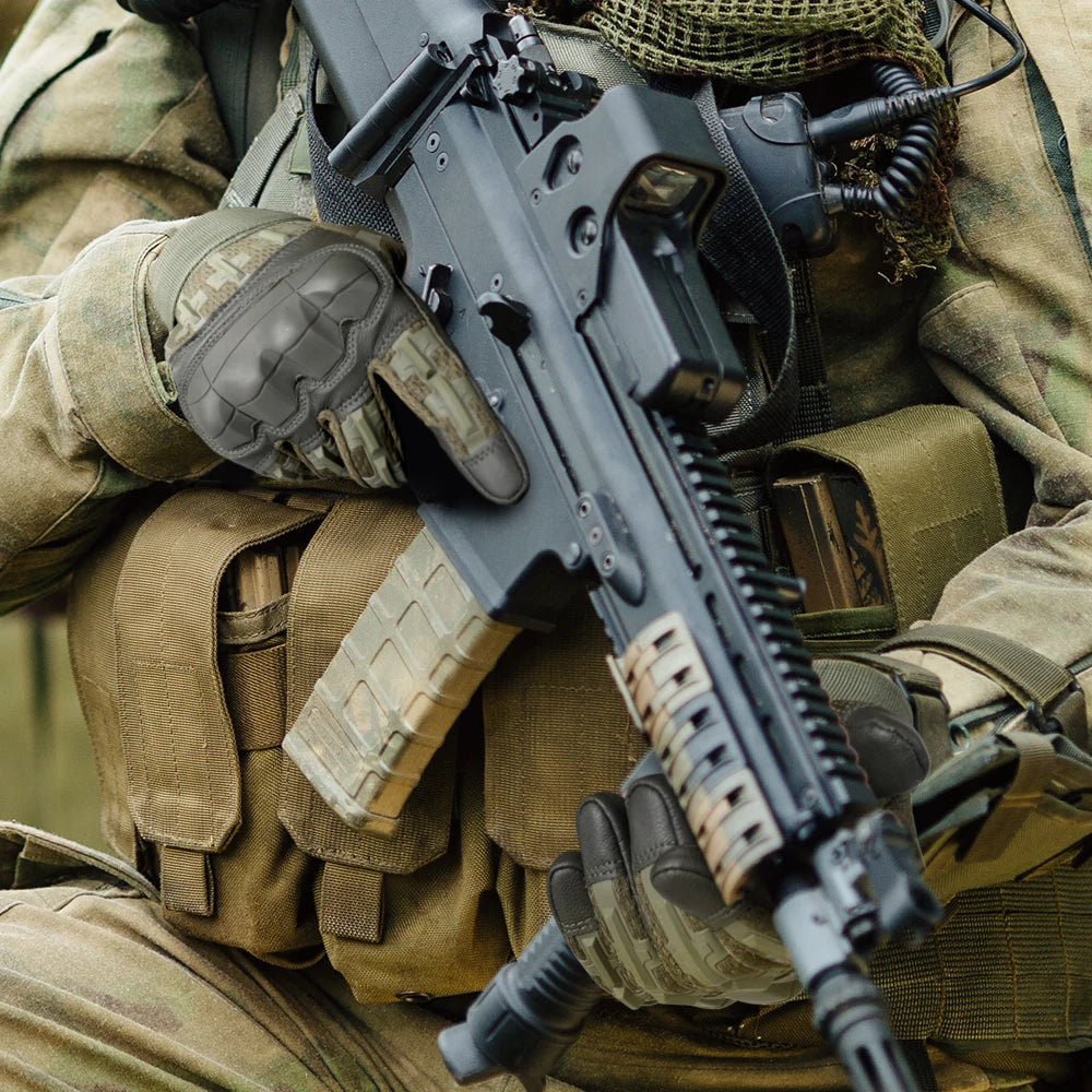 A close-up of a person wearing tactical gloves and holding a black firearm.