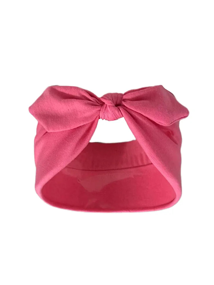 Un bandeau élastique rose noué en nœud, adapté à l'extérieur.