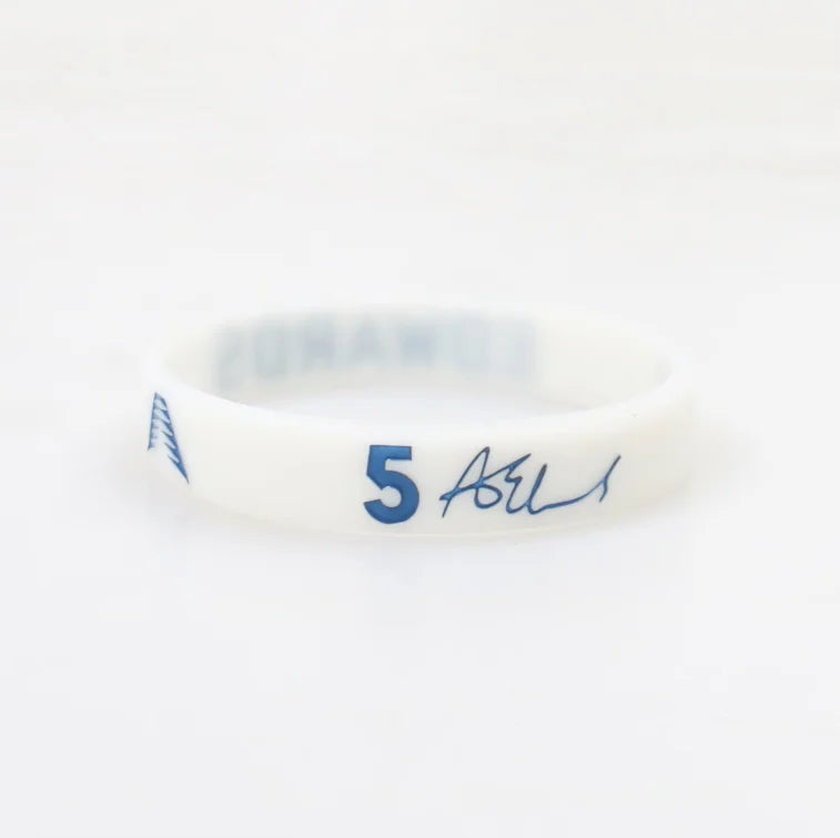 A white silicone wristband with blue text reading 5 and a signature.