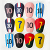 A collection of ten mini football shin guards featuring various numbers and stripes in black, pink, yellow, blue, and red.