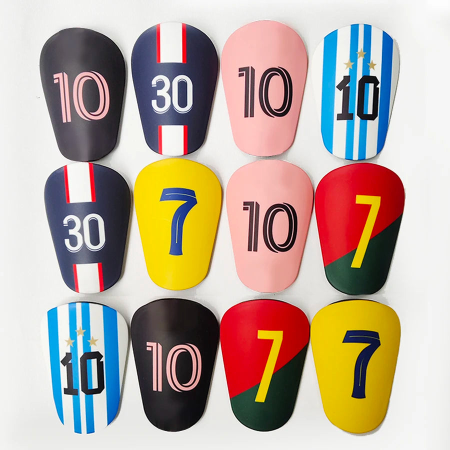 A collection of ten mini football shin guards featuring various numbers and stripes in black, pink, yellow, blue, and red.