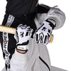 Une personne vêtue d'un équipement sportif noir et blanc tient une batte en bois avec des gants de sport en silicone antidéra