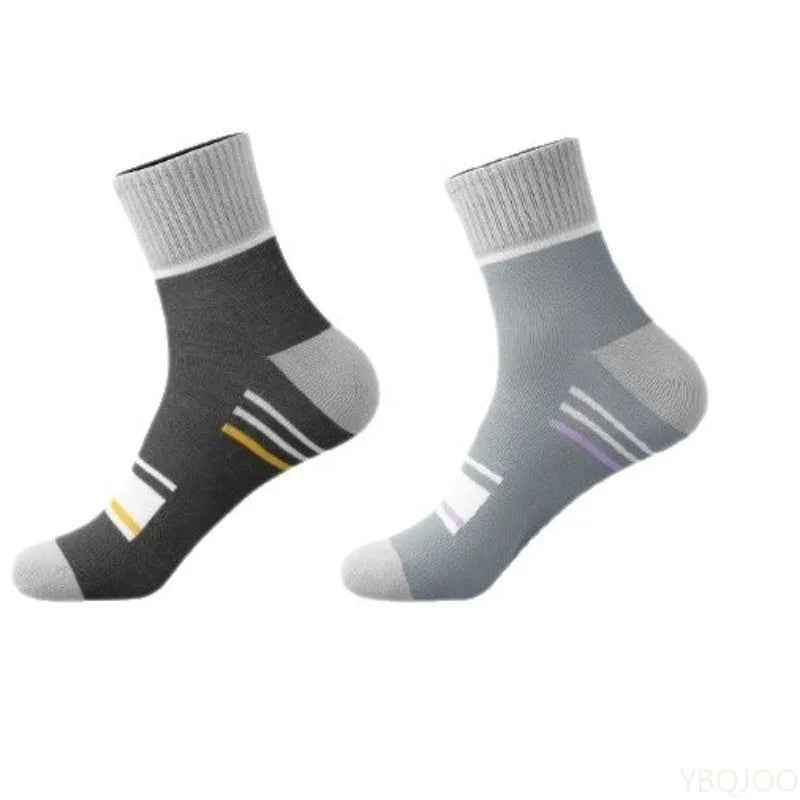 Un par de calcetines deportivos transpirables grises claros y negros, vistos de lado.