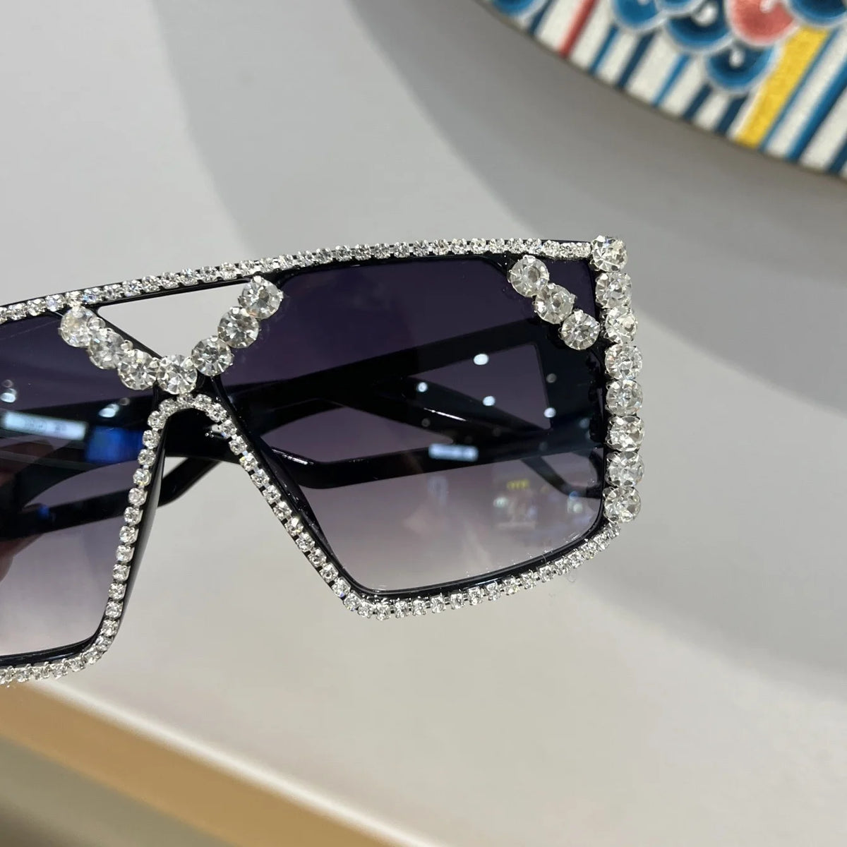 A pair of purple-tinted fashion sunglasses adorned with sparkling rhinestones and geometric detailing.