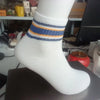 A close-up of a white sock with blue and orange stripes displayed on a dark surface.