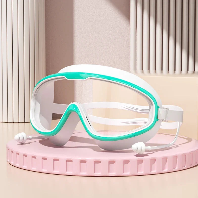 Gafas de natación blancas y turquesa antiempañante sobre un soporte circular rosa.